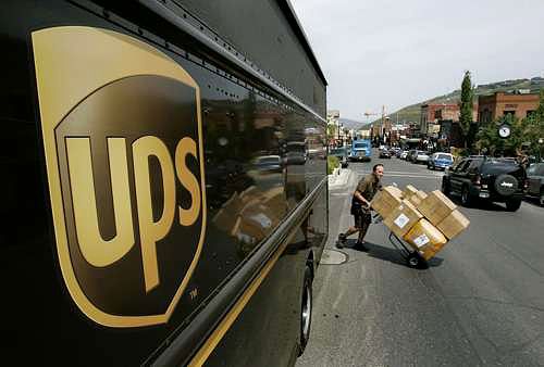 UPS logo en furgoneta y repartidor con carretilla