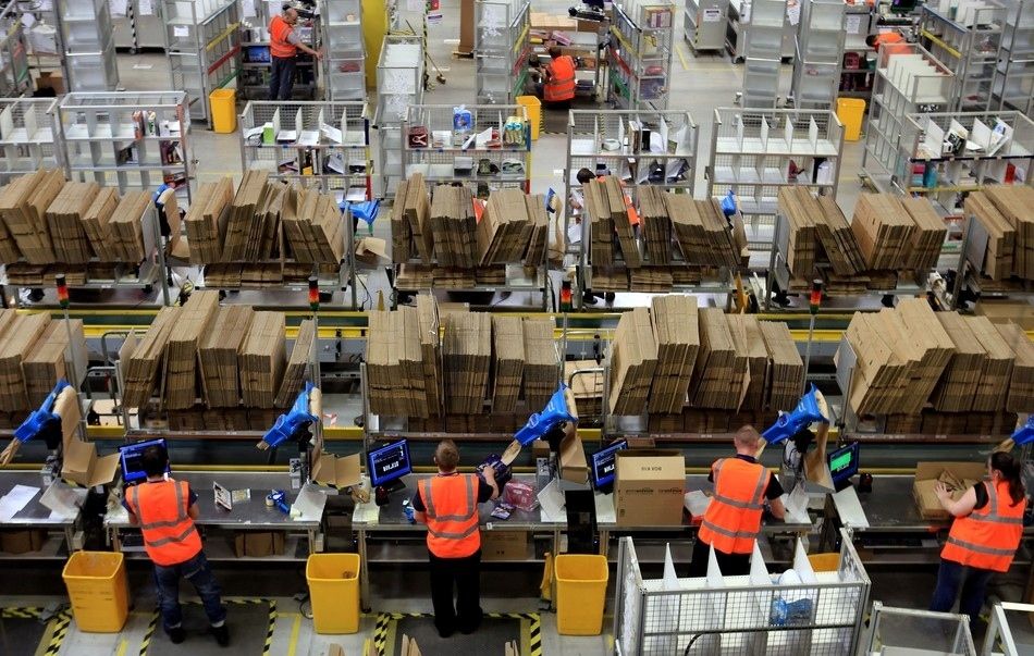Trabajadores en la zona de preparacion de pedidos de un almacen de Amazon