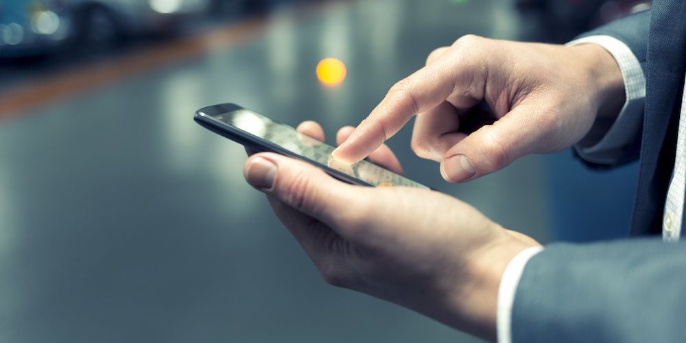 In parking car a man using his mobile phone. Light bokeh background. Filter vintage
