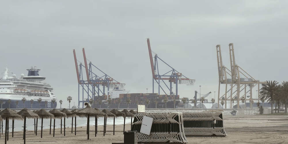 puerto Malaga gruas con sombrillas de la playa en primer termino