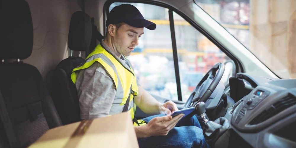 mensajero con tablet en cabina furgoneta entrega distribucion last mile