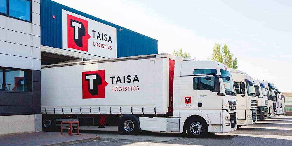 camiones taisa logistics aculados en muelle de nave