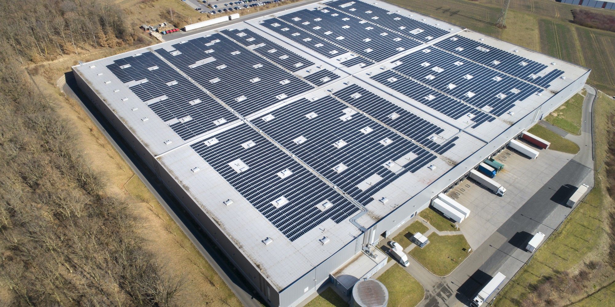 Large industrial building, solar panels and trucks