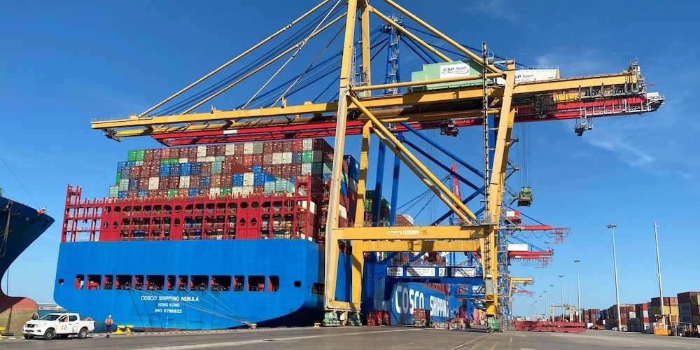 Los contenedores que llegan al puerto de Valencia se descargan de los buques, se cargan en camiones o trenes y se transportan al almacén de DHL en Madrid.