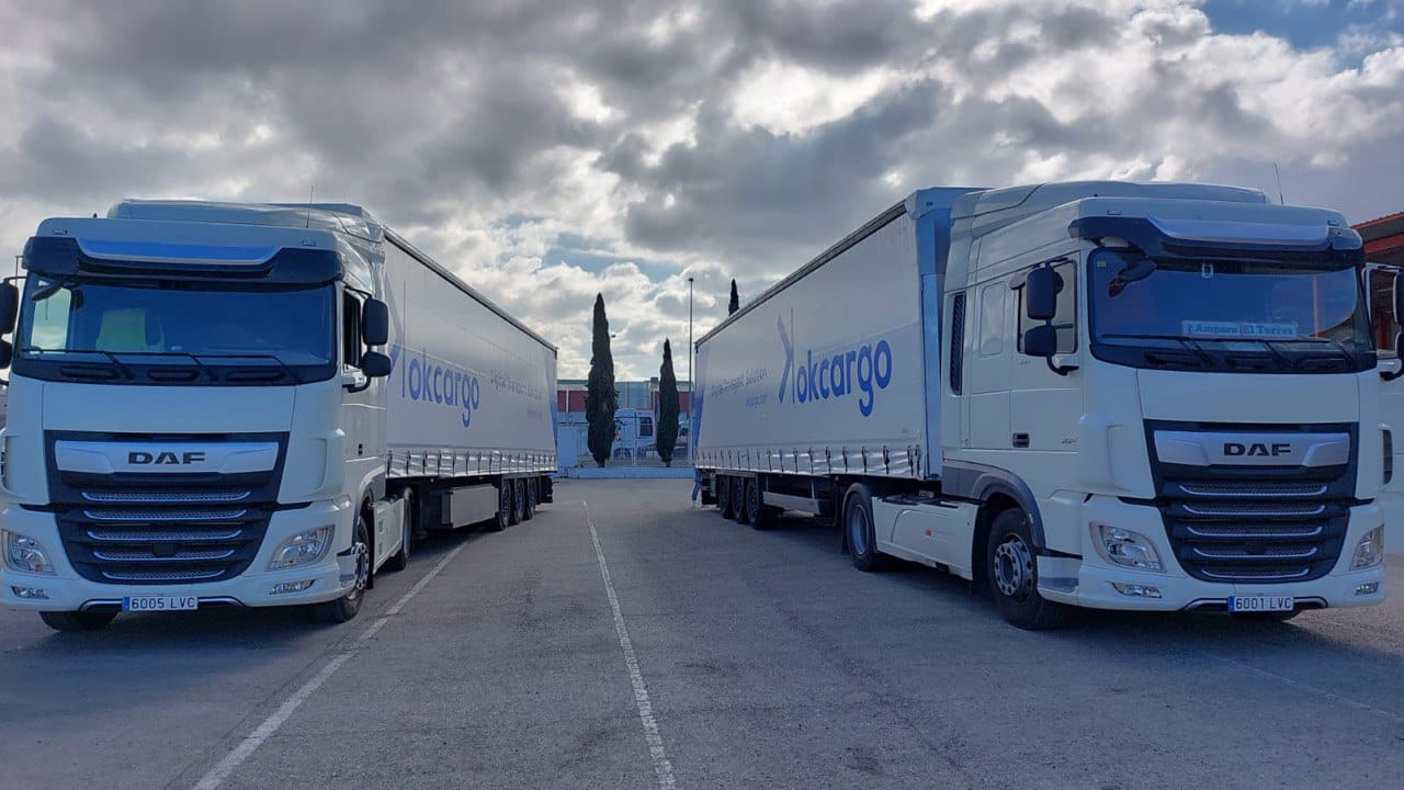 camiones estacionados en paralelo con lona okcargo