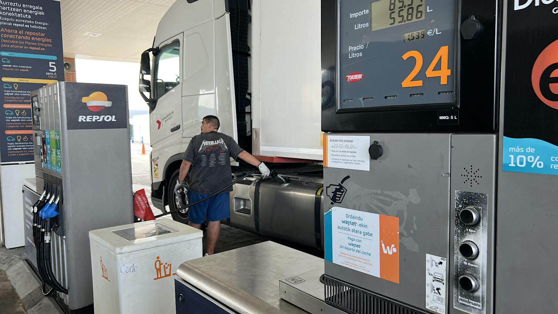 conductor repostando combustible camion en gasolinera Repsol con surtidor