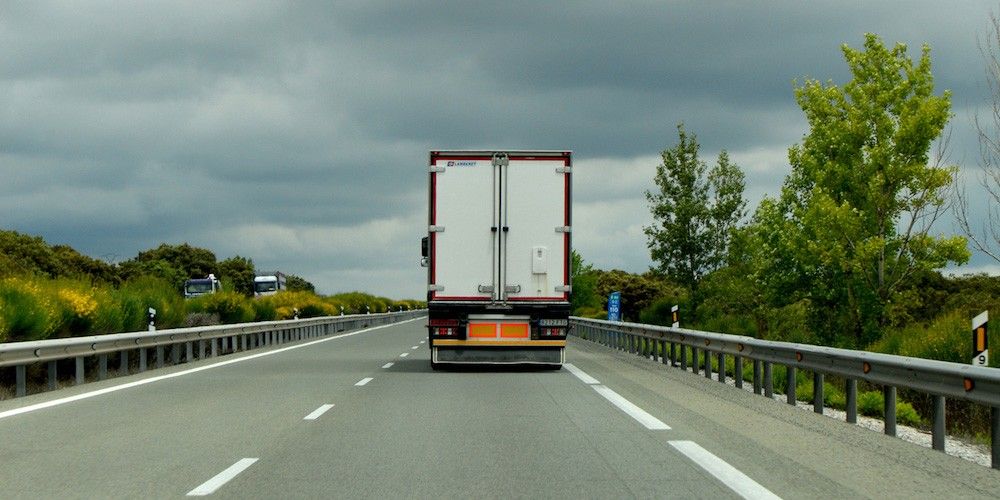 trasera-camion-frigo-en-carretera-centrada-copia trasera-camion-frigo-en-carretera-centrada-copia