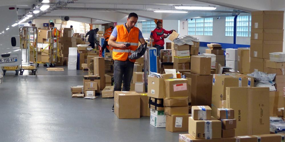 repartidores-clasificando-paquetes-en-hub-urbano-Paris